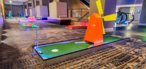 Colorful mini golf course with illuminated obstacles and putting greens, designed for team-building events by Chicago Mini Golf Rentals.
